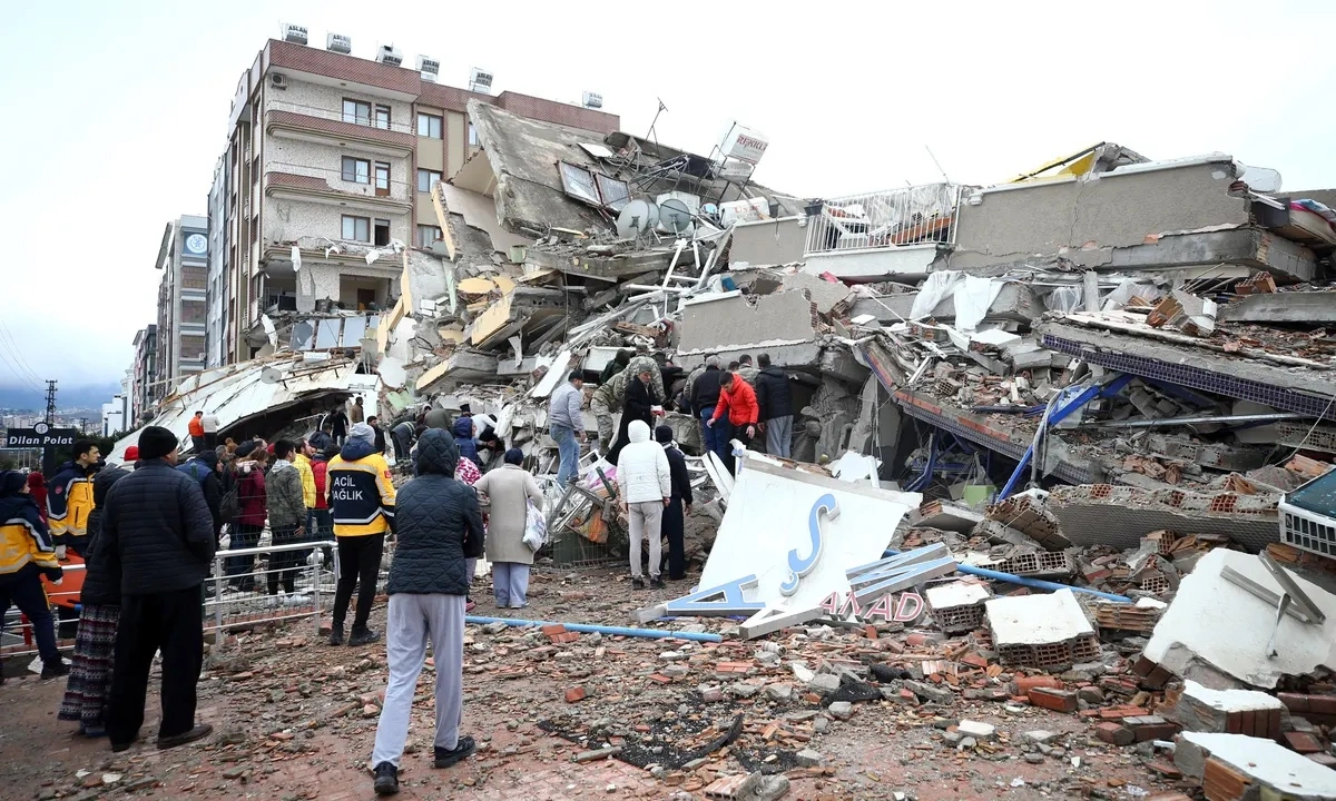 Collapsed building with rescue teams and people after earthquake.