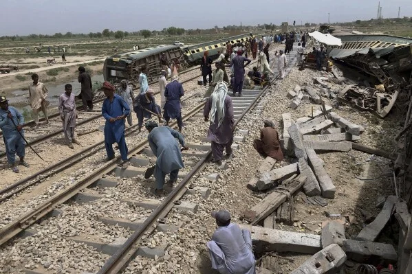 Workers repairing railway tracks after a train derailment in Pakistan—highlighting historical context of Lodhran train accidents.