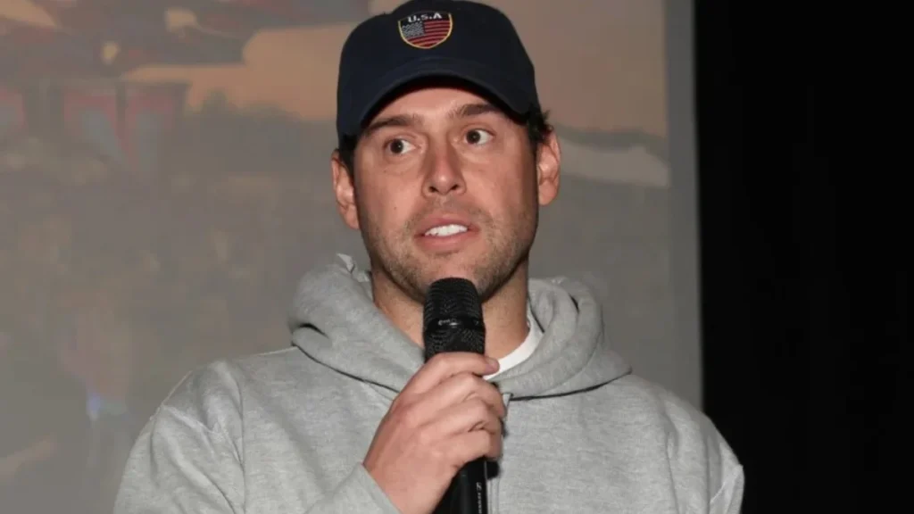 Sco400oter Braun speaks at an event amid Sydney Sweeney & Scooter Braun dating buzz rumors, wearing cap and hoodie.